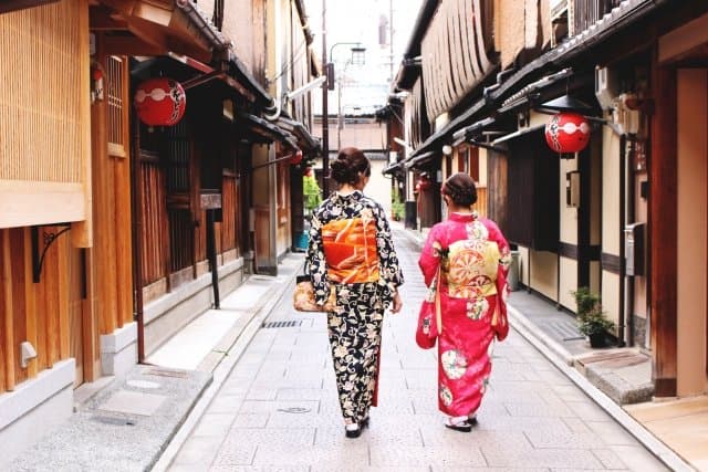 提灯の下がる町家の路地を、着物で歩く二人