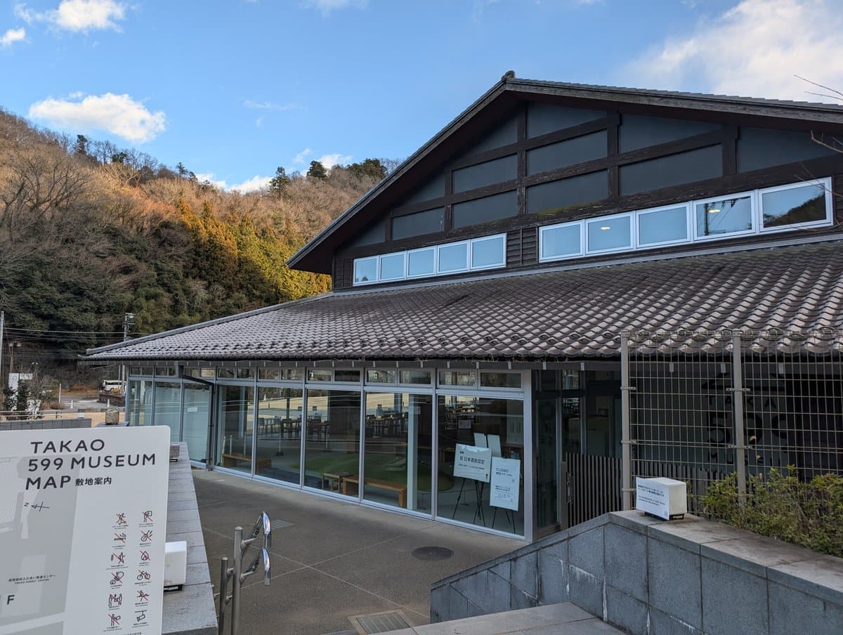 瓦屋根とガラス張りの館と、手前の敷地案内の看板
