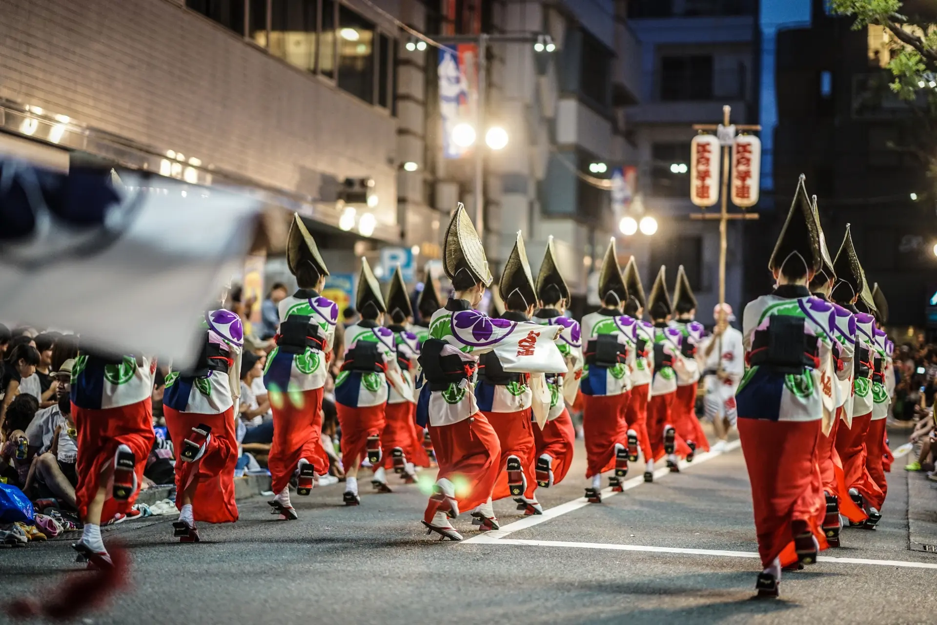 Dancers (ren) performing at a Koenji Awa Odori stage as crowds line the street on a summer evening
