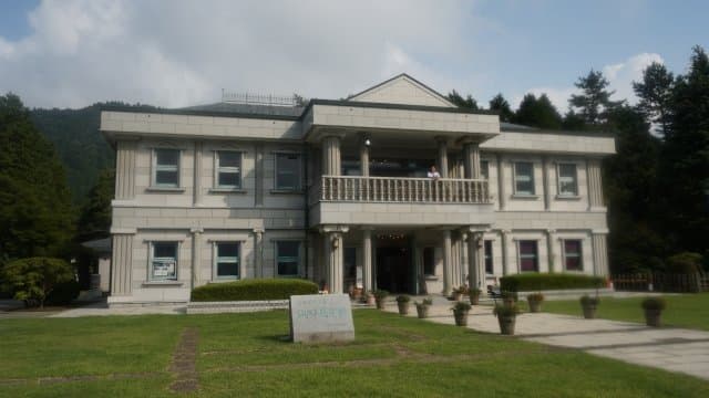 芝生の奥に建つ白い洋館