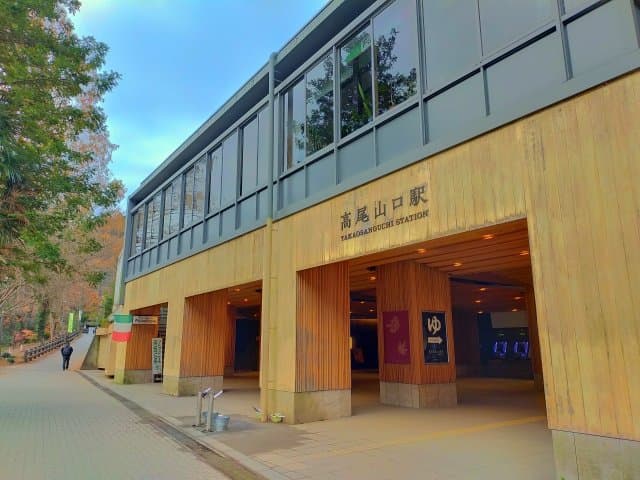 高尾山口駅の駅舎と、奥にのぞく温泉ののれん