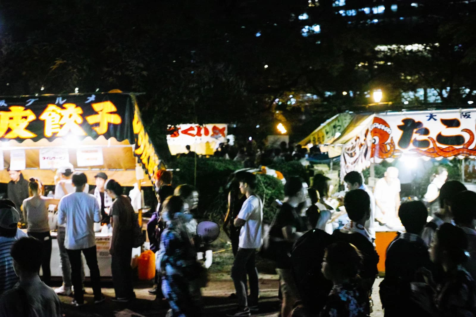 Food stalls and a lively nighttime crowd at a Japanese summer festival